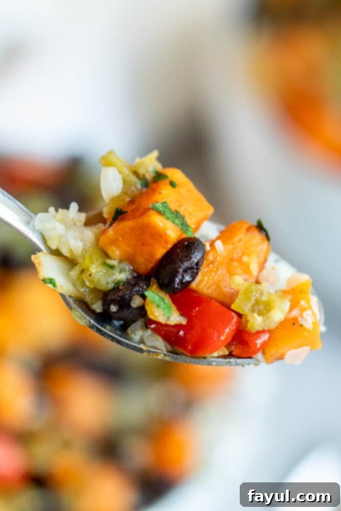 Effortless Veggie Burrito Bowls in Minutes 7 Silver spoon with close up of scoop of burrito bowl filling.