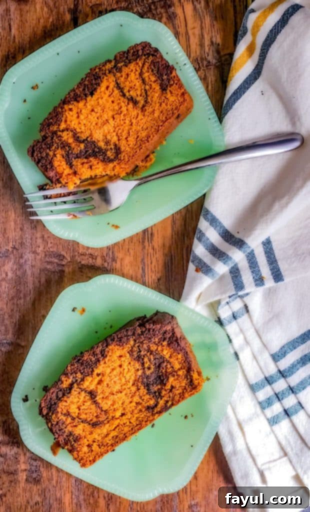 Overhead shot of two green plates with pumpkin bread on them, showcasing the dark chocolate swirl.