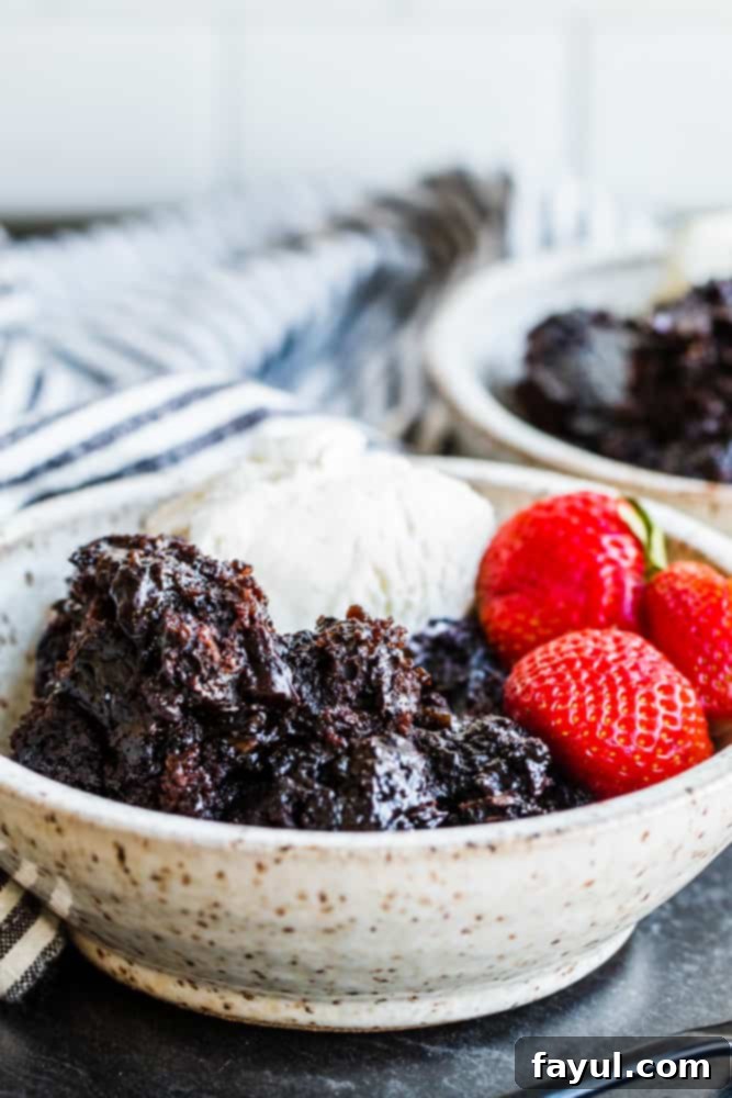 Slow Cooker Molten Chocolate Indulgence 5 Angle shot of lava cake in white bowl on a dark gray background.
