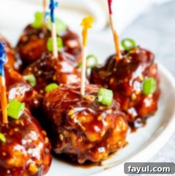 Fiery Asian Pork Meatballs 9 Meatballs on a white plate with toothpicks in them.