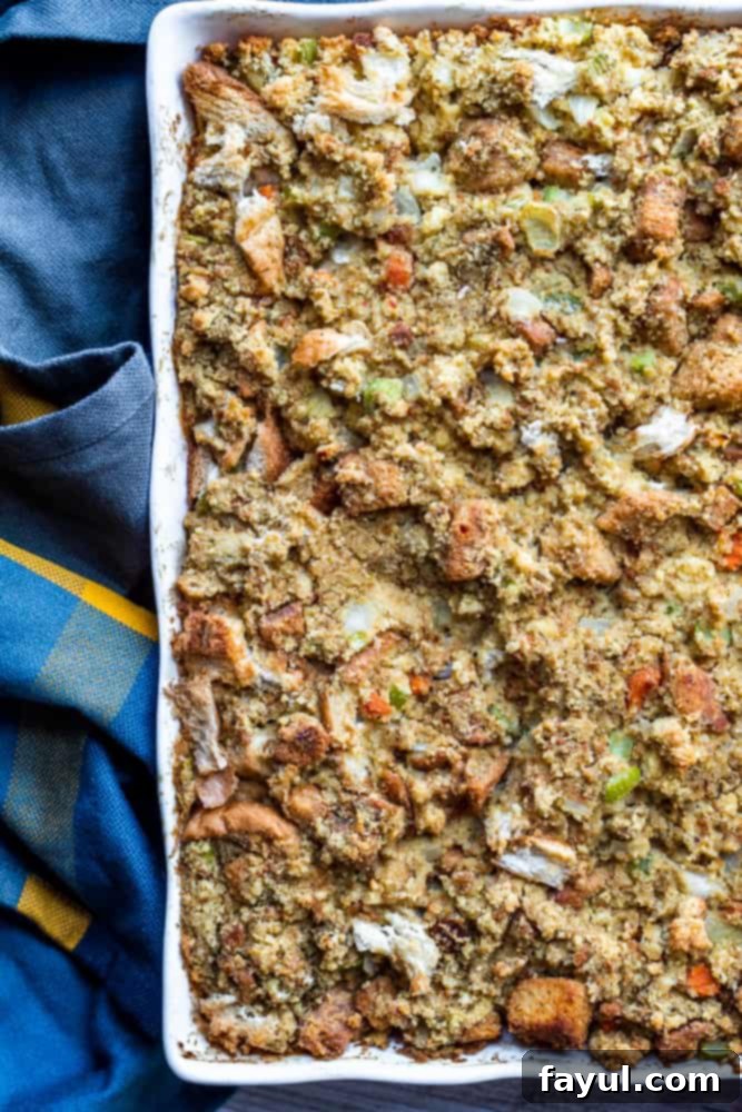 Grandma's Classic Southern Cornbread Dressing 6 Overhead shot of Southern cornbread dressing in white baking dish, with a blue towel on the side for decoration.