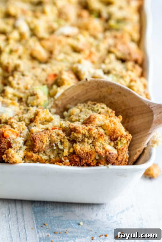 Grandma's Classic Southern Cornbread Dressing 7 Wooden spoon scooping out a portion of the moist Southern cornbread dressing.