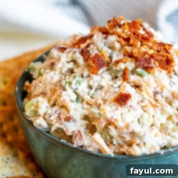 Angle shot of Million Dollar Dip in a blue bowl with crackers surrounding it.