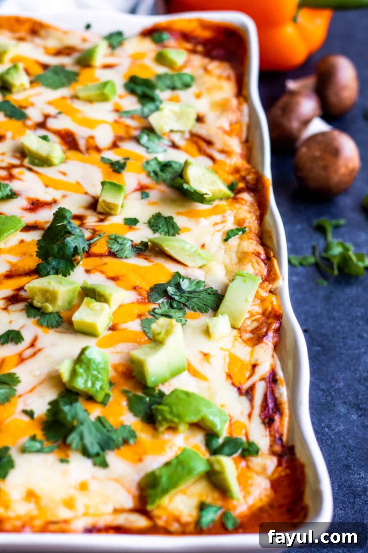 A perfectly baked vegetarian Mexican lasagna in a white baking dish, ready to be served on a blue countertop.