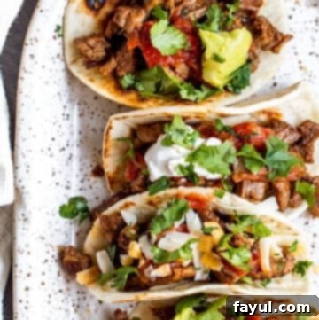 Overhead shot of tacos on a white serving tray.